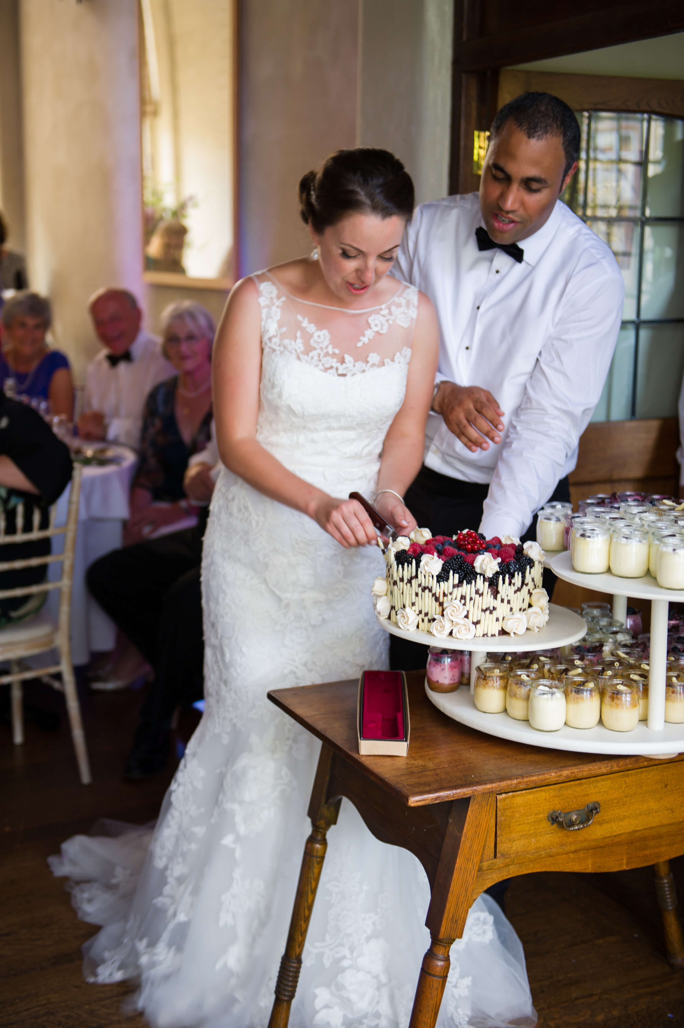 A bride and groom cutting their wedding cake at Voewood House in Norfolk